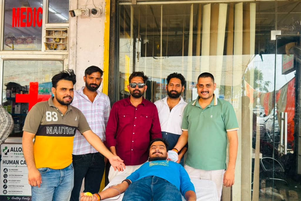 Volunteers standing with a blood donor outside Allomart Pharmacy medical store on Sikar Road, Jaipur